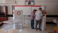 Teachers prepare ballot boxes and cardboard voting booths at a school in Antakya, on May 13, 2023. (Photo by Can Erok / AFP)