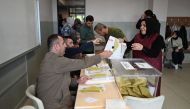 A woman takes ballots at a polling station in Istanbul to vote in the parliamentary and presidental elections in Turkey, on May 14, 2023.  Photo by OZAN KOSE / AFP
