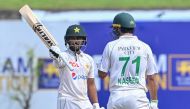 Pakistan's Saud Shakeel (L) celebrates 150 runs as his teammate Naseem Shah watches during the third day of the first cricket Test match between Sri Lanka and Pakistan at the Galle International Cricket Stadium in Galle on July 18, 2023. (Photo by Ishara S. Kodikara / AFP)