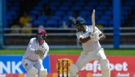 Ravichandran Ashwin (R) of India hits 4 and Joshua Da Silva (L) of West Indies watche during the second day of the second Test cricket match between India and West Indies at Queen's Park Oval in Port of Spain, Trinidad and Tobago, July 21, 2023. (Photo by Randy Brooks / AFP)
