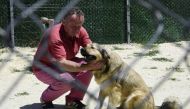 A man tends to a dog in Laika, an animal welfare centre, in Skopje on June 30, 2023. Photo by Robert ATANASOVSKI / AFP