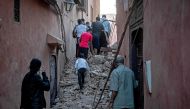 Residents evacuate through the rubble in the earthquake-damaged old city of Marrakesh on September 9, 2023. (Photo by FADEL SENNA / AFP)