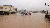 This picture released by the Libyan Red Crescent on September 11, 2023, shows members of their team working on opening roads engulfed in floods at an undefined location in eastern Libya. (Photo by Libyan Red Crescent / AFP) 