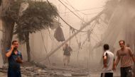Palestinians inspect the destruction in a neighbourhood heavily damaged by Israeli airstrikes on Gaza City's Shati refugee camp early on October 9, 2023. (Photo by Mahmud Hams / AFP)