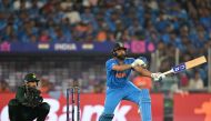 India's captain Rohit Sharma (R) plays a shot as Pakistan's wicketkeeper Mohammad Rizwan watches during the 2023 ICC Men's Cricket World Cup one-day international (ODI) match between India and Pakistan at the Narendra Modi Stadium in Ahmedabad on October 14, 2023. (Photo by Sajjad HUSSAIN / AFP)
