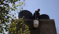 A man lifts a water bucket to the roof to refill a the water tank in a house in the Rafah refugee camp, in the southern of Gaza Strip on Octobers 15, 2023. (Photo by Mohammed Abed / AFP)