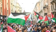 People wave flags as they march during a demonstration in support of Palestinians in Milan yesterday.