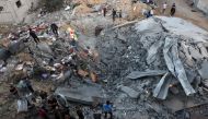 People check the rubble of a building destroyed in an Israeli bombardment in Rafah in the southern Gaza Strip on October 21, 2023. (Photo by Mohammed Abed / AFP)