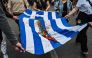Demonstrators and students symbolically carry a blood-stained Greek flag with red flowers, during a march towards the US embassy in Athens on November 17, 2023, to commemorate the 50th anniversary of the 1973 students' uprising against a US-backed junta. (Photo by Theophile Bloudanis / AFP)

