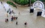 Pedestrians try to pass a flooded street following heavy rains at Kiembeni district in Mombasa on November 17, 2023. (Photo by STRINGER / AFP)