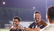 Al Sadd's Hassan Al Haydos (left) and coach Wesam Rizik.