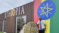 Tessema Asrate poses with his 3D coffee bean sculpture in front of the Ethiopian pavilion at Expo Doha. (Pics: Marivie Alabanza / The Peninsula)