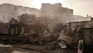 A man stands next to heavily damaged houses and shops, a day after a gas explosion in the Embakasi area of Nairobi, on February 2, 2024. (Photo by LUIS TATO / AFP)