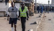 An injured man walks at the Embakasi neighbourhood with heavily damaged houses and shops, a day after a gas explosion in Nairobi, on February 2, 2024. (Photo by LUIS TATO / AFP)
