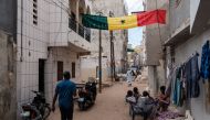 A large Senegalese flag hangs across a street in a neighbourhood in Dakar on February 13, 2024. (Photo by GUY PETERSON / AFP)
