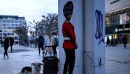 A dog stands next to a column with the mural of a London Guard on the main shopping street in Frankfurt am Main, western Germany, on February 28, 2024. (Photo by Kirill KUDRYAVTSEV / AFP)
