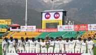 India's players pose with the trophy after winning the fifth and last Test cricket match between India and England at the Himachal Pradesh Cricket Association Stadium in Dharamsala on March 9, 2024. (Photo by Sajjad HUSSAIN / AFP)