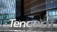 Photo taken on July 10, 2022 shows people walking past the Tencent headquarters in Shenzhen in China's southern Guangdong province. Photo Credit: Jade GAO / AFP.