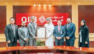 QIIB Deputy CEO, Jamal Abdullah Al Jamal with other officials receiving the payment security and protection of bank cards data certification.