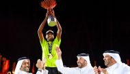 Mutaz Marshim celebrates after receiving the trophy from Second Vice President of Qatar Olympic Committee Dr Thani bin Abdulrahman Al Kuwari.