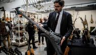 Auctioneer Etienne De Baecque holds the Warwick 4-string Buzzard bass guitar designed by John Entwistle, bassist of famous rock band The Who in a room of De Baecke auction house, in Lyon, on May 22, 2024 as people examine music instruments on the eve of the auction. (Photo by Jeff Pachoud / AFP) /