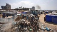 A bulldozer removes piles of garbage at a camp for internally displaced Palestinians in Deir al-Balah in the central Gaza Strip on June 3, 2024. (Photo by Bashar Taleb / AFP)

