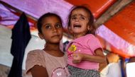 Hana Abdelrahaman al-Rai, a four-year-old child suffering from malnutrition and displaced from Gaza City's eastern suburb of Shujaiya, reacts as she is carried inside a tent in Zawayda in the central Gaza Strip on June 4, 2024. (Photo by Bashar Taleb / AFP)