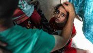 An injured child reacts following Israeli bombardment on al-Bureij, as she sits on the floor at a ward at the Aqsa Martyrs hospital in Deir el-Balah in the central gaza Strip on June 4, 2024. (Photo by Bashar TALEB / AFP)
