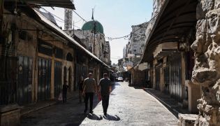Palestinians walk through deserted commercial area in Nablus, occupied West Bank. AFP file photo.
