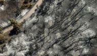 An aerial view shows a burned house following a wildfire in the village of Varnavas on August 14, 2024. (Photo by Angelos TZORTZINIS / AFP)
