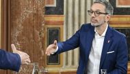 Herbert Kickl, leader and top candidate of right-wing populist Freedom Party of Austria (FPOe) shakes hands with Karl Nehammer, Austrian Chancellor, leader and top candidate of Austrian People's Party (OeVP) at the start of a TV debate at the parliament after exit poll numbers were announced in Vienna on September 29, 2024, during Austria's general election.  (Photo by Hans Klaus Techt / APA / AFP)