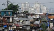 This picture shows shanty homes along a floodway before high rise buildings in Manila on October 4, 2024. (Photo by Ted ALJIBE / AFP)
