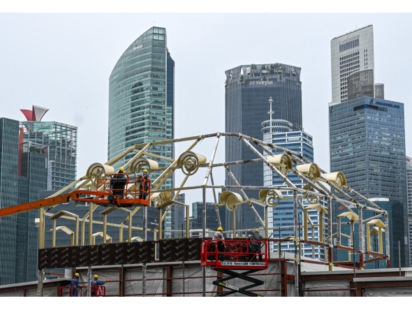 File photo of workers assembling a structure near the financial business district in Singapore.