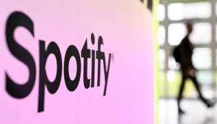 A person walks past a banner with an Spotify logo at the Frankfurt book fair on October 17, 2024. Photo by Kirill KUDRYAVTSEV / AFP