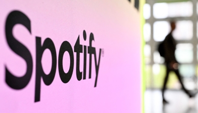 A person walks past a banner with an Spotify logo at the Frankfurt book fair on October 17, 2024. Photo by Kirill KUDRYAVTSEV / AFP