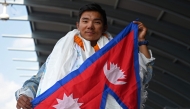 Nepali mountaineer Nima Rinji Sherpa poses upon his arrival at the airport in Kathmandu on October 14, 2024. Photo by Prakash MATHEMA / AFP

