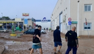 Men walk in a street covered in mud following floods in Picanya, near Valencia, eastern Spain, on October 30, 2024. (Photo by Jose Jordan / AFP) 