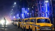 This photograph taken on February 1, 2025 shows Hindustan Ambassador yellow taxis parked along a roadside in Kolkata. (Photo by Dibyangshu Sarkar / AFP) 