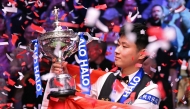 China's Zhao Xintong poses with the trophy after victory over Wales' Mark Williams in the World Championship Snooker final at The Crucible in Sheffield, northern England on May 5, 2025. Zhao Xintong became the first Chinese player to win the World Snooker Championship as the qualifier completed his stunning march to the title with a 18-12 victory against Mark Williams in the final on Monday. (Photo by Oli SCARFF / AFP)

