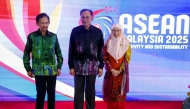 Malaysia's Prime Minister Anwar Ibrahim (C) with wife Wan Azizah Wan Ismail (R) poses alongside Sultan of Brunei Hassanal Bolkiah before a gala dinner during the 46th Association of Southeast Asian Nations (ASEAN) Summit in Kuala Lumpur on May 26, 2025. (Photo by Fazry Ismail / POOL / AFP)