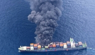 This handout photograph taken and released on June 9, 2025 by the Indian Coast Guard (ICG) shows smoke billowing from a cargo vessel that caught fire off Beypore coast in India's Kerala state. (Photo by Indian Coast Guard (ICG) / AFP) 