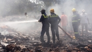 Firefighters work at the site where Air India flight 171 crashed in a residential area near the airport in Ahmedabad on June 12, 2025. (Photo by Sam Panthaky / AFP)