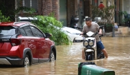 A man rides through a flooded street in Zhongshan, in China's southern Guangdong province on June 17, 2025. (Photo by AFP) 