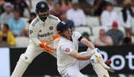 England's Harry Brook plays a sweep to the boundary while falling to the ground as India's wicket keeper Rishabh Pant (L) looks on on day three of the first cricket test match between England and India at Headingley cricket ground in Leeds, northern England on June 22, 2025. (Photo by Darren Staples / AFP) 