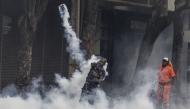 A protester hurls a teargas canister at Kenya police officers during clashes in downtown Nairobi on June 25, 2025 during a planned day of protest marking the first anniversary of the storming of the parliament. (Photo by SIMON MAINA / AFP)