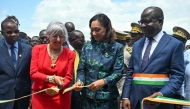 Swiss Interior Minister Elisabeth Baume-Schneider (second left) cuts an inaugural band flanked by Ivorian Minister of Culture and Francophonie Françoise Remarck (centre), Ivorian Minister of Health Pierre Demba (right) during the inauguration of an extension of Ivory Coast's first archaeological museum in the village of Singrobo-Ahouty near Tiassale on June 30, 2025. (Photo by Issouf Sanogo / AFP)