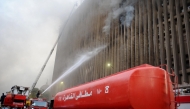 Firefighters douse the flames after a fire broke out in the Telephones landline exchanging station and Ministry of Communications building in the heart of Cairo on July 7, 2025. (Photo by AFP)