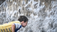A boy cools himself off in a fountain in Moscow on July 8, 2025. The temperature in Moscow has reached 32 degrees Celsius, (90F) and 36 centigrade (97F) is expected by the end of the week. Photo by Alexander NEMENOV / AFP.
