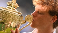 Italy's Jannik Sinner kisses the winner's trophy as he poses for pictures following his victory against Spain's Carlos Alcaraz at the end of their men's singles final tennis match on the fourteenth day of the 2025 Wimbledon Championships at The All England Lawn Tennis and Croquet Club in Wimbledon, southwest London, on July 13, 2025. (Photo by Kirill KUDRYAVTSEV / AFP)