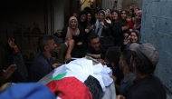Palestinians mourn a relative, killed the night before in an Israeli strike, during their funeral in Gaza City on July 29, 2025. (Photo by Omar AL-QATTAA / AFP)

